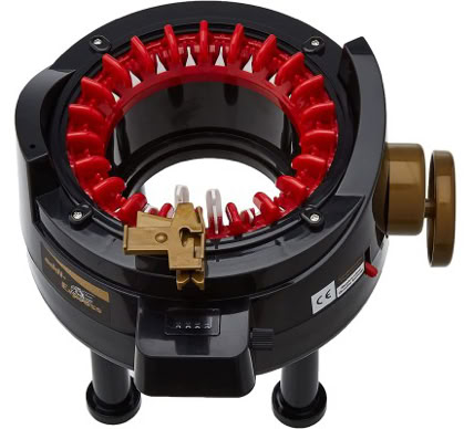 A circular knitting machine with red needles and a black base, placed on a white surface.